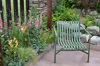 Seat next to naturalistic planting and bordered by corten steel fence in the 'Elements of Sheffield' garden at the RHS Chatsworth Flower Show 2019.