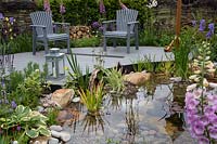 'RHS Garden for Wildlife Wild Woven' - RHS Chatsworth Flower Show 2019 - pond with curved deck and seating area, amongst naturalistic planting.