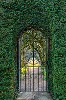 View through metal gateway to garden beyond. Fittleworth House, West Sussex, UK.
