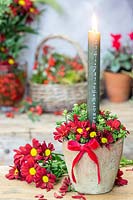 Calendar candle in rustic pot with red Chrysanthemum and bow