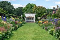 The 90-metre-long twin herbaceous borders with view to Grade II listed alcove at the end. Arley Hall, Cheshire, UK.
