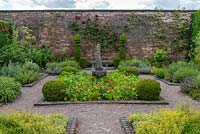The Herb Garden. A small, formal, walled space planted with herbs, annuals, box topiary and roses. Arley Hall, Cheshire, UK.