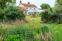 Country house and garden - Veronicastrum 'Fascination', Nepeta subsessilis 'Blue Dreams', Lythrum salicaria 'Blush' in mixed border