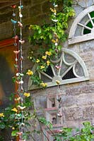 Old arched window frames and Indian Hanging Decoration adorn the side of the house.