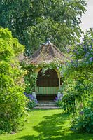 View to octagonal summerhouse covered with Rosa 'Climbing Cecile Brunner'
