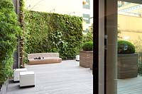 View through the corner of the garden featuring  wooden decking, vertical living wall, various seating places