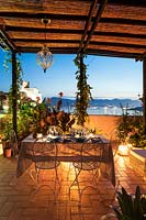 Outdoor dining area illuminated at night with views to Lerici's Castle and harbour. Italy.