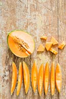 Melon 'Retato' cut up into slices on a chopping board