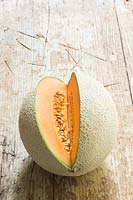 Melon 'Retato' - showing outside netted skin and a section cut through to show flesh and seeds