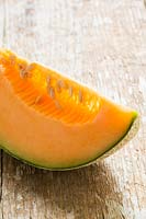 Melon 'Retato', a slice showing orange flesh and seed cavity