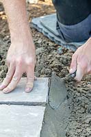 Man using trowel to smooth and finish cement edge