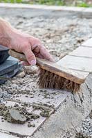 Man using small brush to remove excess grout