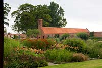 View over extensive flower beds within a walled country garden 