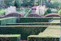 View over formal hedges of Taxus baccata to the Grasses Parterre. Wave form hedge of Fagus sylvatica. 