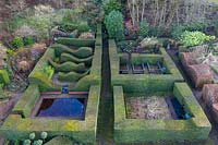 View over Reflecting Pool and Hedge Gardens. Formal hedges and columns of Taxus baccata. Veddw House Garden, Monmouthshire, Wales, UK. Garden designed and created by Anne Wareham and Charles Hawes.
