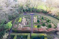 View over the Grasses Parterre, with wave-form hedges of Fagus sylvatica and cones of Taxus baccata. Veddw House Garden, Monmouthshire, Wales, UK. Garden designed and created by Anne Wareham and Charles Hawes. 