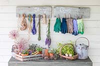 Rustic boards with wooden pegs attached for storing string and gloves