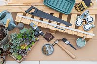 Tools and materials for creating a succulent plant pallet table on castors. 
