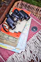 Binoculars, compass and stack of maps 