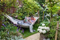 Garden owner Ross relaxing in hammock while reading
