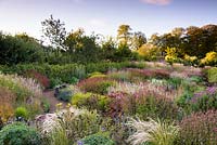 Over view of large bed, grasses include: silvery Jarava ichu and  Carex muskingumensis amongst flowering perennials such as Sanguisorba, Monarda, Persicaria amplexicaulis 'Firetail' and Eupatorium 