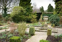 The Leisure Garden with a stone urn and variegated clipped box at its centre at Rodmarton Manor, Glos, UK. 