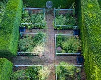 Overhead view of formal garden enclosed by Taxus baccata hedging.  Brick path through beds.  The Cornfield Garden. Veddw House Garden