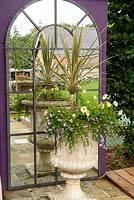Large arched mirror with urn and mixed planting