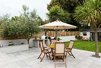 Wooden dining furniture on patio with umbrella