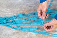 Woman tying knots in fabric cord