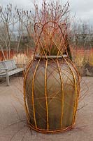 Large pot decorated with Salix stems - RHS Garden Hyde Hall, Essex