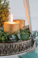 Detail of hanging advent arrangement with gold candles, miniature christmas tree and Eucalyptus and Hebe foliage