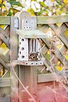 Insect hotel mounted on fence post
