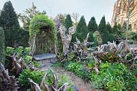 The Stumpery garden in spring with decorative sculptural logs and a living sculpture seat. Arundel Castle, West Sussex, UK.