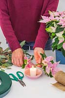 Woman sealing end of flower stem by holding it in flame for 30 seconds