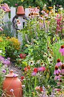 Plants to attract beneficial insects in vegetable garden -  Agastache 'Blue Fortune', Ecninacea 'White Swan', Echinacea 'Magnus' and Dahlia 'Topmix Red'.