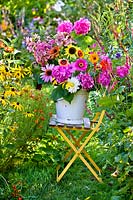Bucket of summer flowers  - sunflowers, zinnias, dahlias, phlox, hydrangea, rose mallow and cleome.