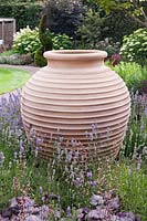 Large decorative terracotta pot surrounded by Heuchera 'Silver Scrolls' and Lavandula angustifolia - July, Cheshire