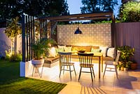 Illuminated dinning area with colourful chairs, modern pergola and industrial style lamp.