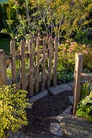A rustic, wooden picket garden gate in country garden. The Water Spout garden, RHS Malvern Spring Show, 2016. Designer: Christian Dowle