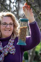 Hanging up a bird feeder filled with mealworms