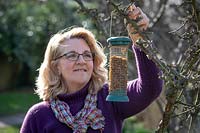 Hanging up a bird feeder filled with mealworms
