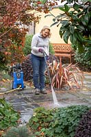 Cleaning a patio with a pressure washer.