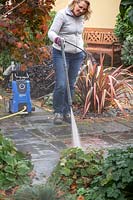 Cleaning a patio with a pressure washer.