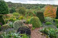 Topiary in country garden with views to landscape beyond in September 