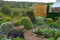 Formal area of cottage garden with views to landscape beyond in September 