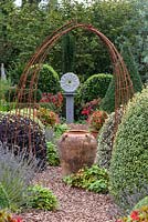 Small formal country garden with sculpture and ornaments as focal points 