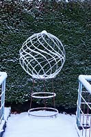 Spiral globe of mild steel with snow. Veddw House Garden
