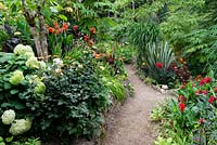 View through valley garden with tender exotic plants bordering pathway