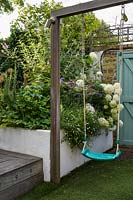 Family Small Hackney Garden  - swing and raised bed with planting with Allium, white Hydrangea and Erigeronby Earth Designs